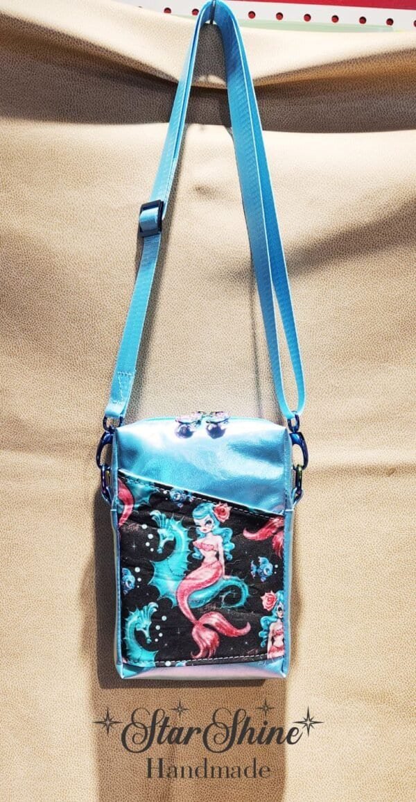 Small crossbody blue bag with a mermaid design on it