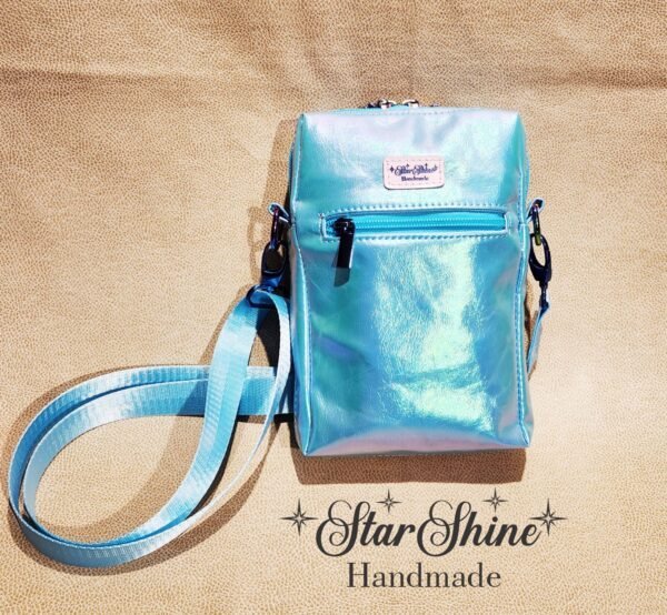 Small crossbody blue bag with a mermaid design on it, rear view